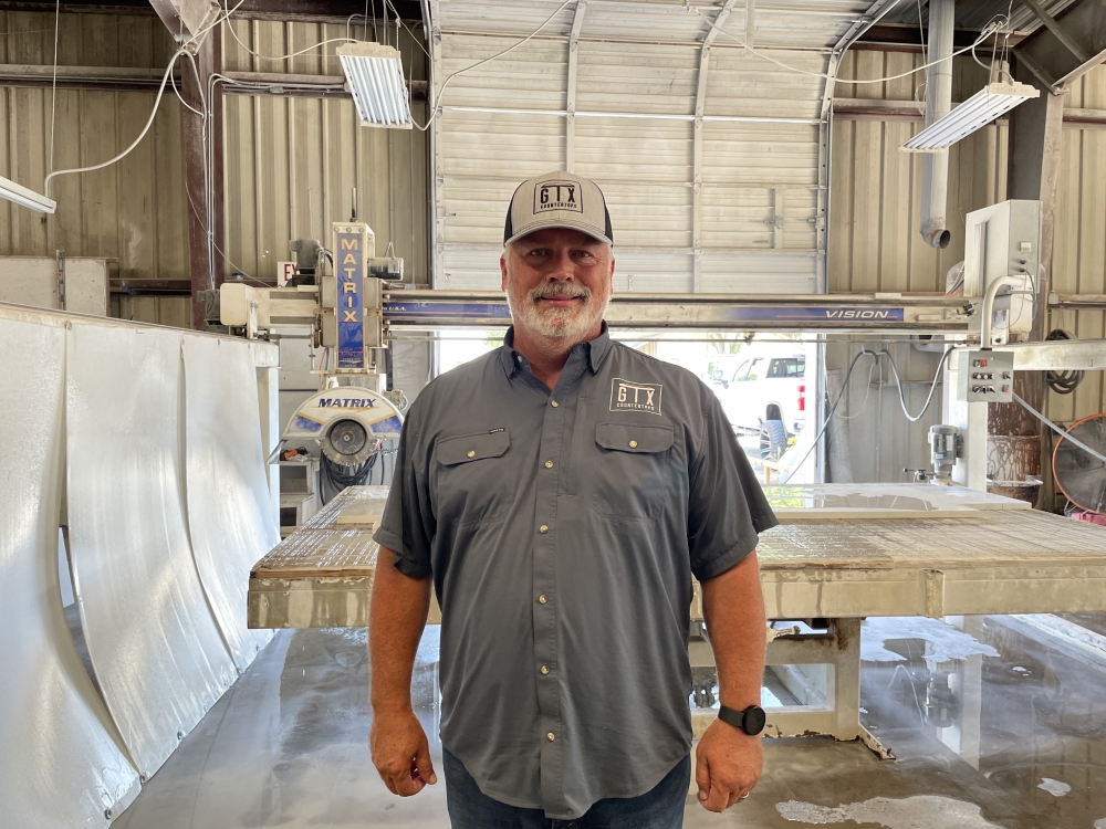 GTX Countertops President Rory Pettway poses in front of a Matrix saw machine in the 5,000 square-foot Georgetown fabrication shop. (Anna Maness/Community Impact) 