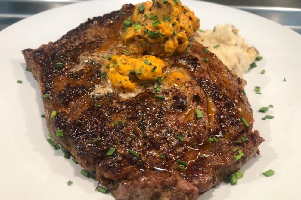 The 12-ounce black angus ribeye ($28) is served 'Cajun style' with mashed potatoes and chipotle lime butter. (Courtesy Magnolia Cajun Comfort)