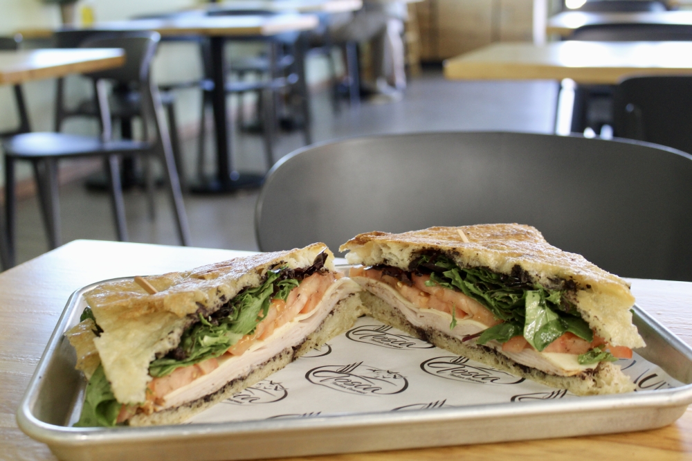 The Milano sandwich ($15) is made with focaccia, smoked turkey, olives paste, tomatoes, spring mix and gouda cheese. (Jovanna Aguilar/Community Impact)