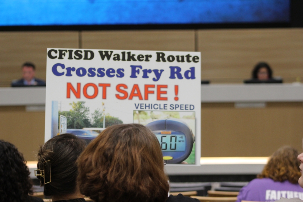 Several parents held signs advocating for bus service to be reinstated for all students at the Cy-Fair ISD board meeting Oct. 7. (Danica Lloyd/Community Impact)