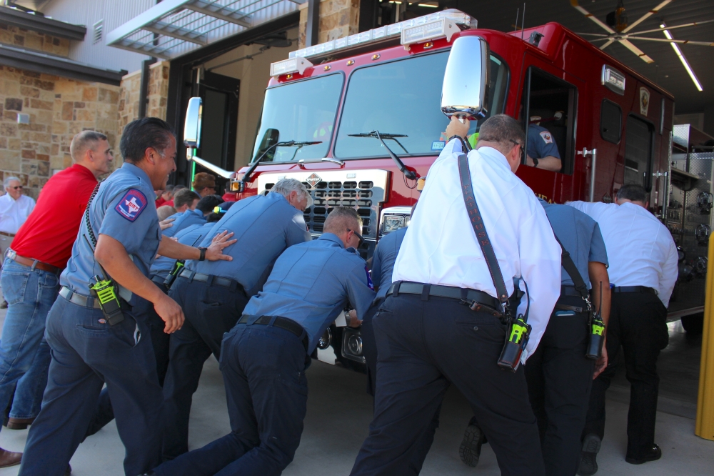 Fulshear Simonton Fire Department firefighters push the first fire engine into Fire Station No. 4 as part of Oct. 9's grand opening celebration. (Kelly Schafler/Community Impact)