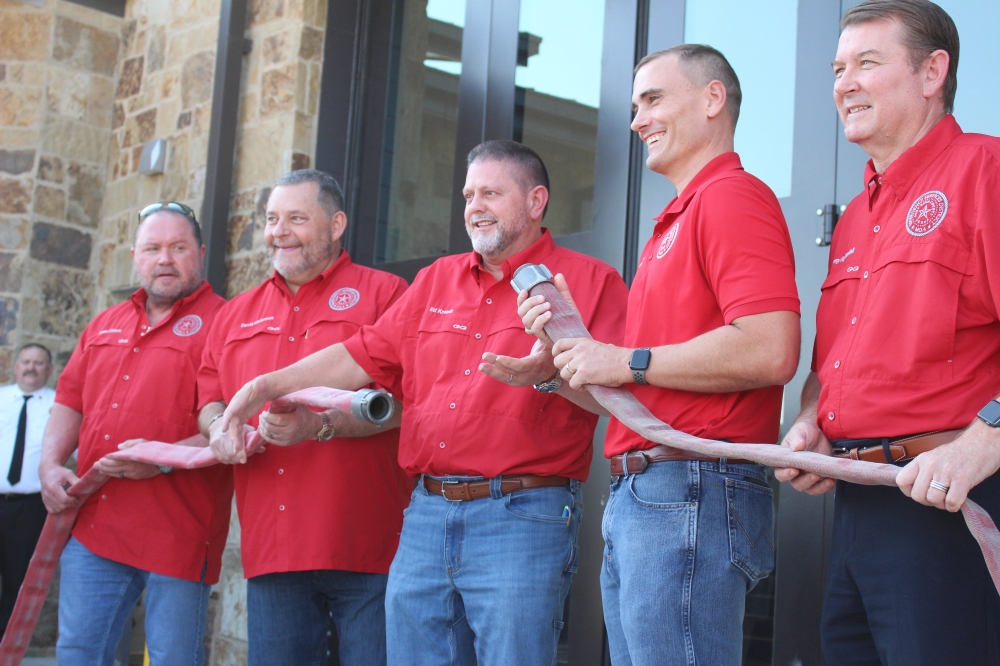 Members of the board of commissioners for Fort Bend County Emergency Services District No. 4 uncoupled a fire hose as part of Oct. 9's grand opening celebration. (Kelly Schafler/Community Impact)
