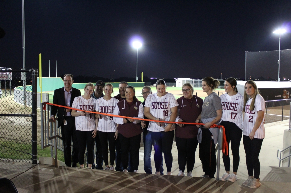 The Rouse High School softball team celebrated the completion of a new artificial turf field alongside Superintendent Bruce Gearing. (Chloe Young/Community Impact)