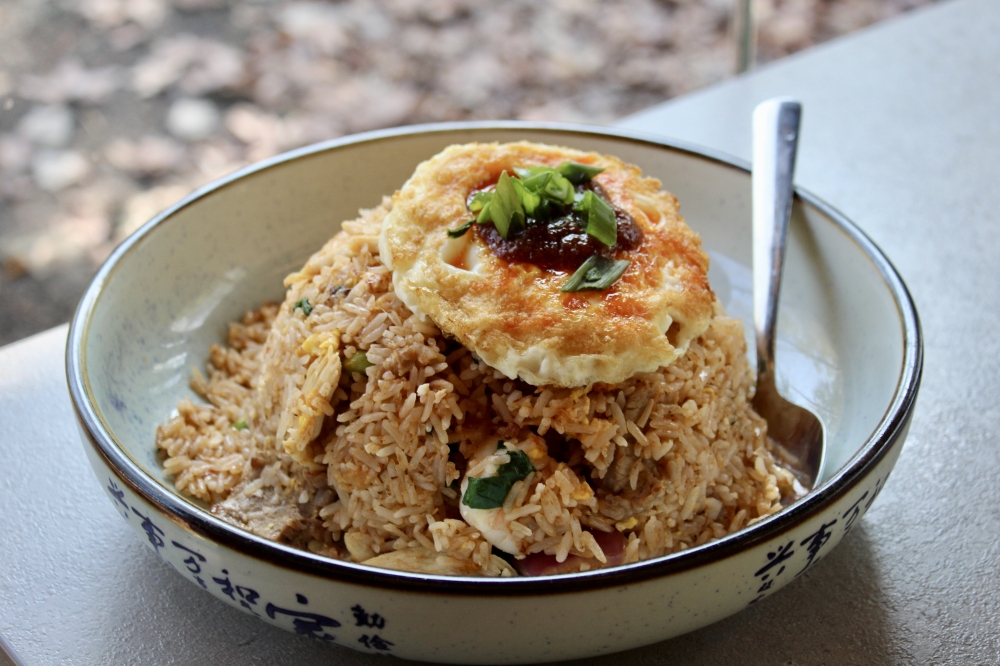 The Malaysian fried rice ($18) is made with chicken, beef, shrimp, belacan, yuchoy, tomato and is topped with a fried egg. (Jovanna Aguilar/Community Impact)