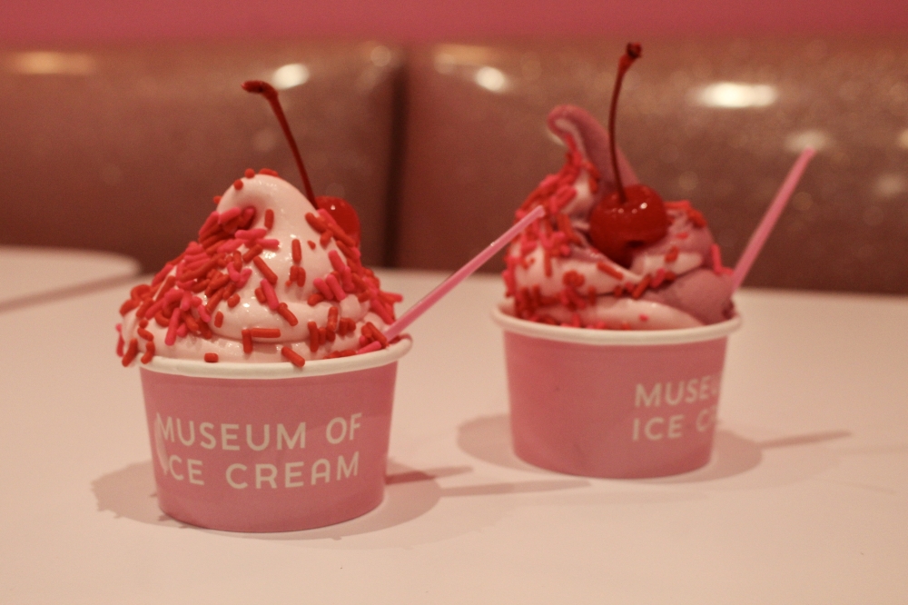 The Museum of Ice Cream offers various ice cream flavors to guests throughout the exhibit, including the year-round Pink Vanilla soft serve (left) with and a swirl of Pink Vanilla, vegan cherry soft serve (right) with the option to add sprinkles and a maraschino cherry. (Sarah Hernandez/Community Impact)