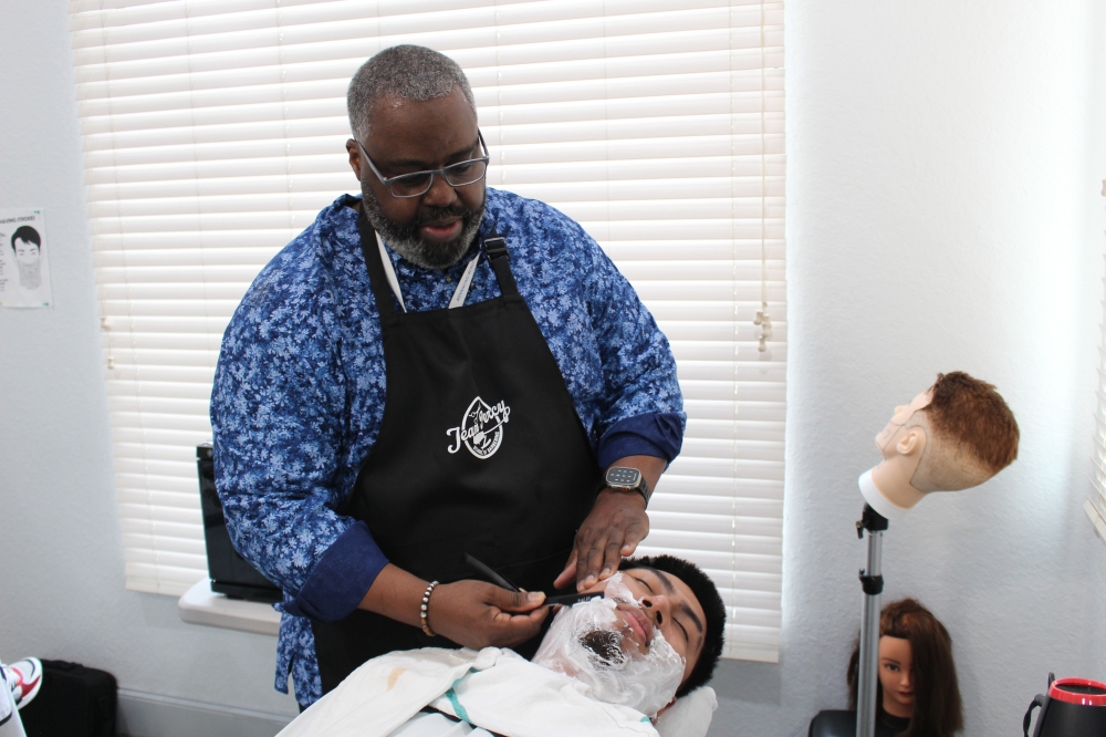 Jean Percy School of Barbering Owner Alfred Ross performs a practice shave on a student during a Jan. 14 class. (Ryan Reynolds/Community Impact)