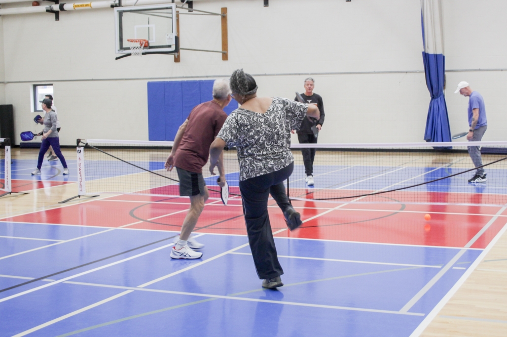 Robert Isles (left), Miriam Gonzalez (center) and Tom Fink (back, center) played a few rounds of pickleball at the TownLake YMCA on Jan. 9. (Elisabeth Jimenez/Community Impact)