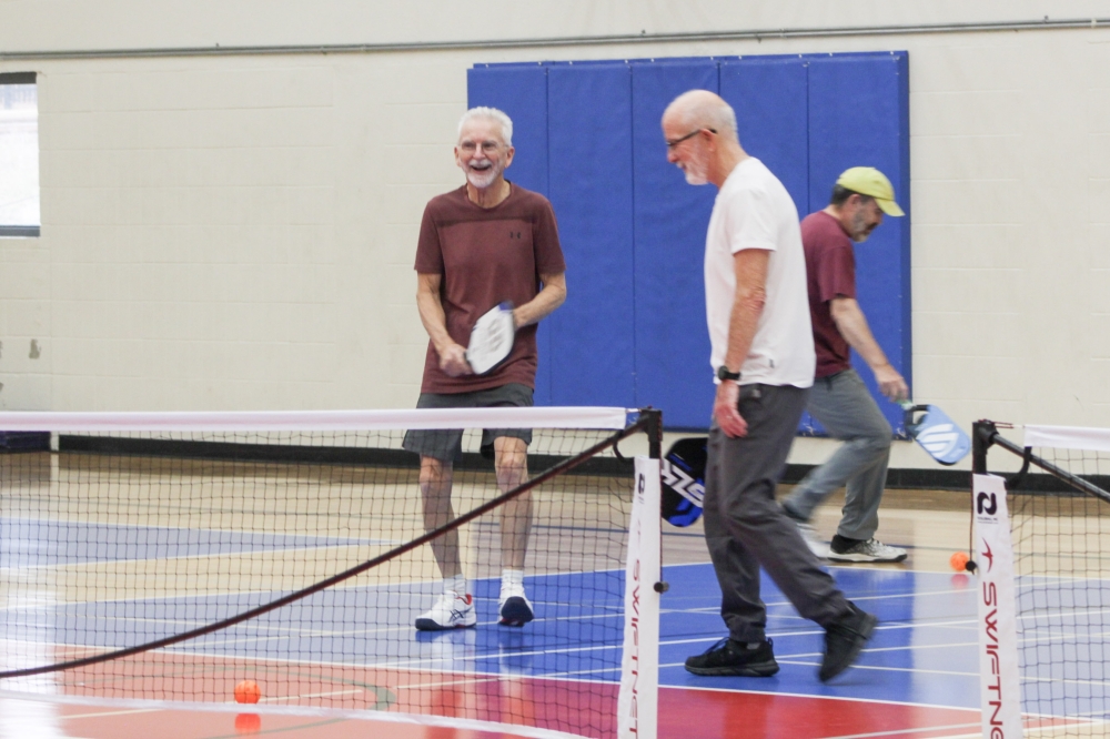 Robert Isles (center) said the mental focus required for pickleball can be beneficial, especially for seniors. (Elisabeth Jimenez/Community Impact)