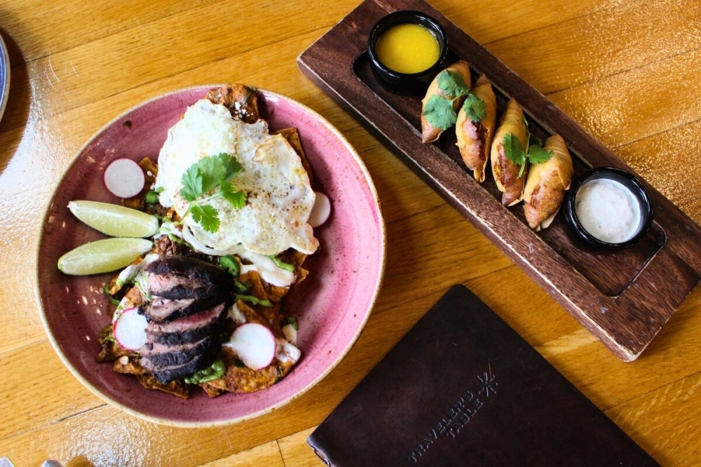 Traveler's Table brunch menu includes duck chilaquiles ($26) and crab samosas ($17). (Asia Armour/Community Impact)