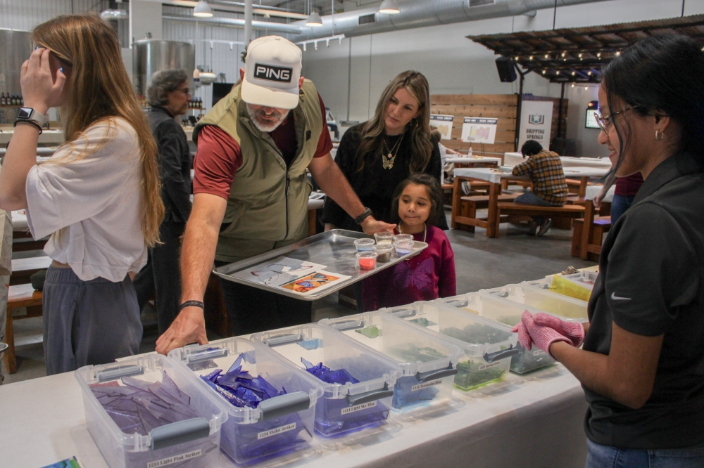 Library Director Mindy Laird (center, right) and her family stopped by the Dripping Springs Community Library donor event to decorate a glass butterfly (Elisabeth Jimenez/Community Impact)