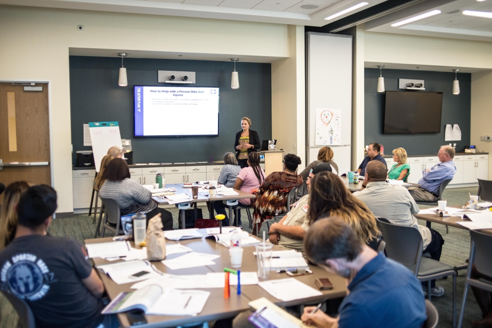 Youth Mental Health First Aid training participants take notes and listen to speaker