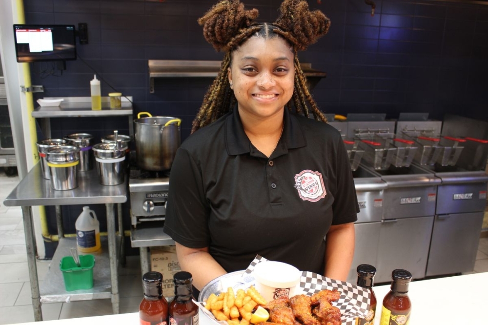 Tyla Simone Crayton, owner of Sienna Wings and creator of Sienna Sauce, started her business while still a sophomore in high school. As she prepares to graduate from college, she said she plans to earn a million dollars from marketing and growing the brand. (Asia Armour/Community Impact)