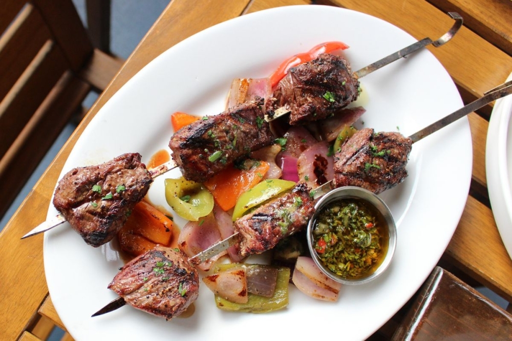 The grilled butcher skewers ($33) are made with filet mignon and are served with charred veggies and chimichurri butter and choice of two sides. (Asia Armour/Community Impact)