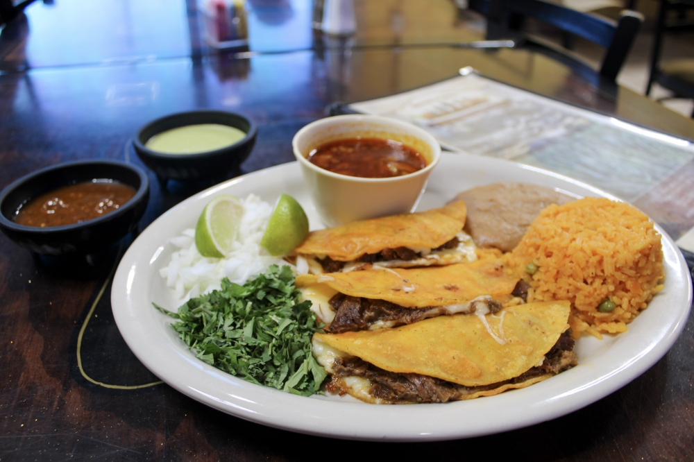 The Quesa Birria Plate includes barrio tacos with rice, beans, onions and cilantro, $17. (Dacia Garcia/Community Impact)