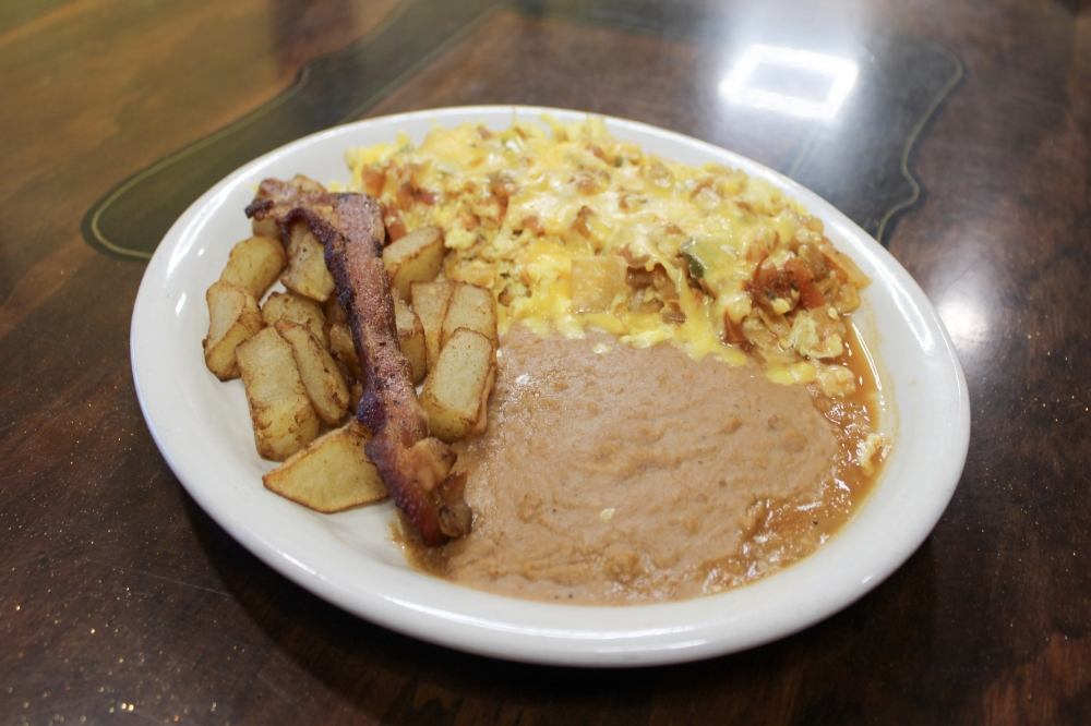 The Migas Rancheras feature eggs mixed with crispy corn tortillas topped with ranchero sauce and melted cheese, $14. (Dacia Garcia/Community Impact)