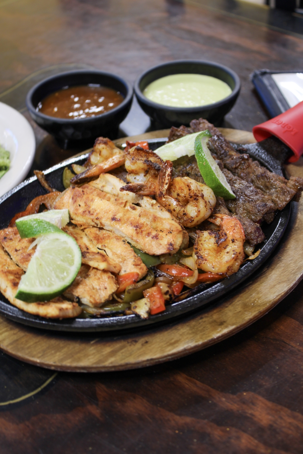 The Parrillada Mixta comes with beef, chicken fajitas, grilled shrimp, salad, pico de gallo, guacamole, sour cream, cheese, rice and charro beans, $25. (Dacia Garcia/Community Impact)