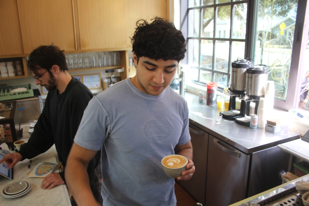 Barista Julio Granadillo makes a latte for a customer. (Gracie Warhurst/Community Impact)