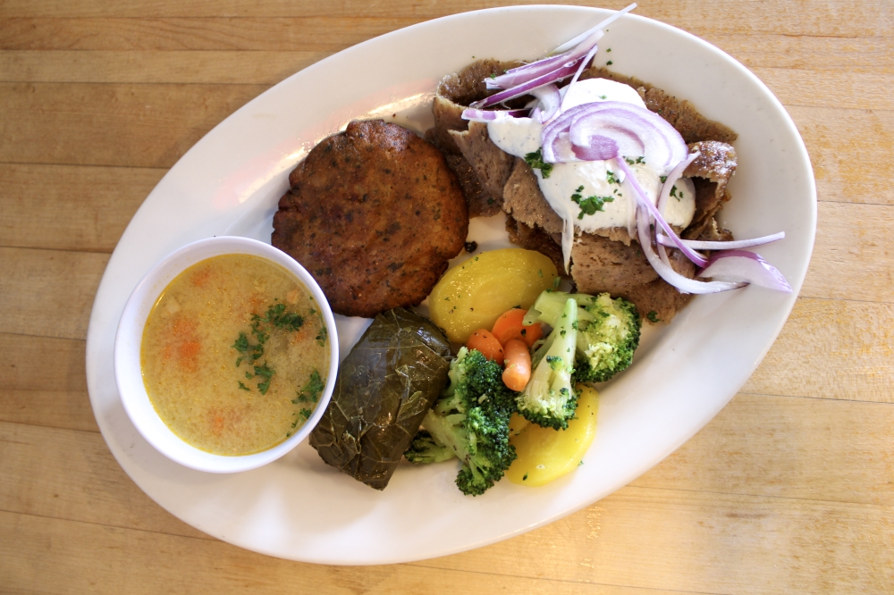 During lunchtime customers may order any entrees and sides they would like cafeteria-style at the service counter. Pictured is the Gyro Plate served with a cup of Lemon Chicken Soup, Dolma and vegetables, $12.95+. (Dacia Garcia/Community Impact)