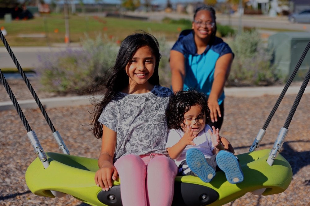 Kids on swing in energy-efficient community in Austin