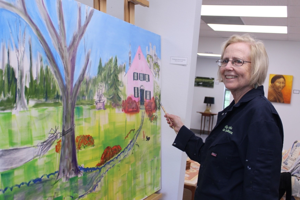 Artist Emily Startz painting original fine art at an art gallery in The Woodlands