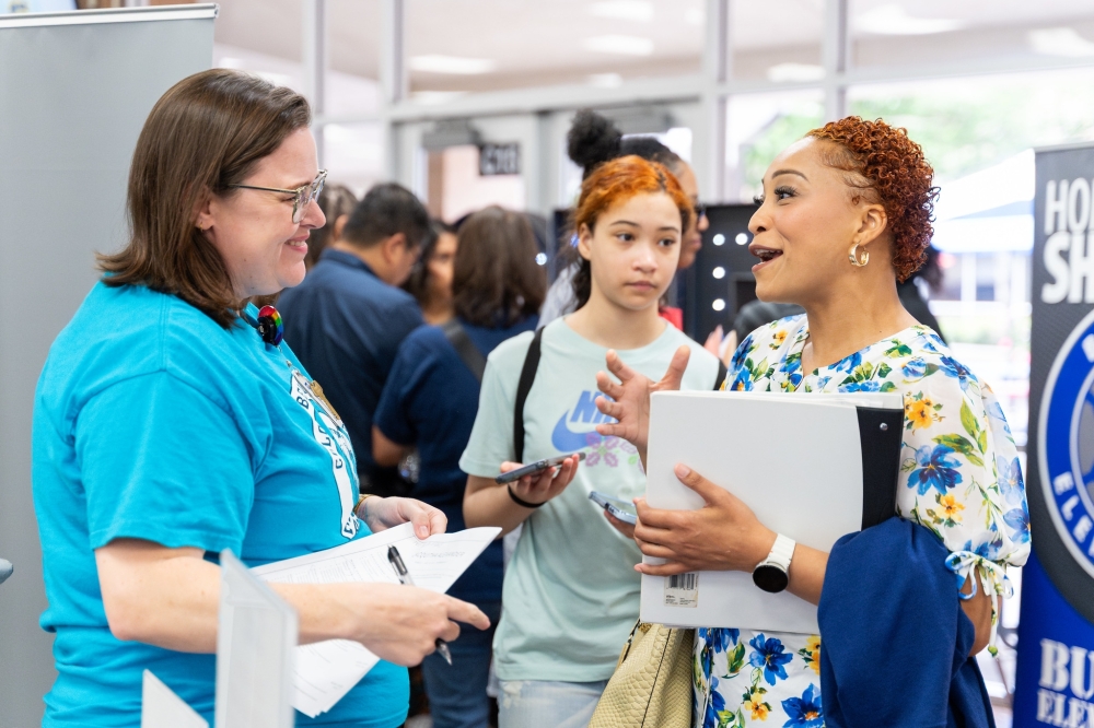 professional speaking to recruiter at job fair about benefits of working at Fort Bend ISD