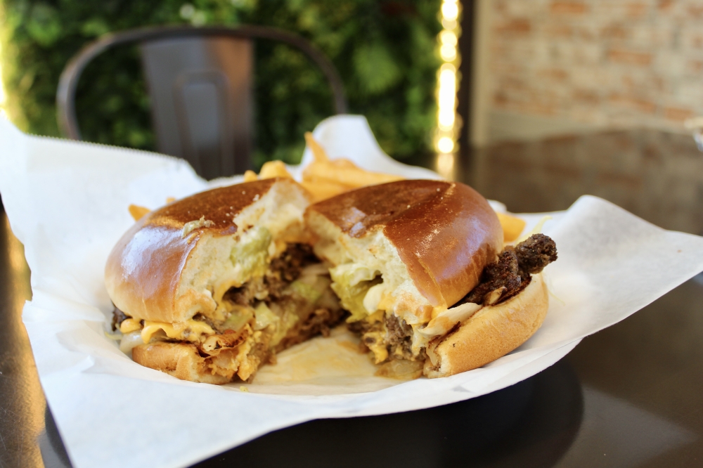 The smashed burger ($12.99) is served with fries. (Jovanna Aguilar/Community Impact)