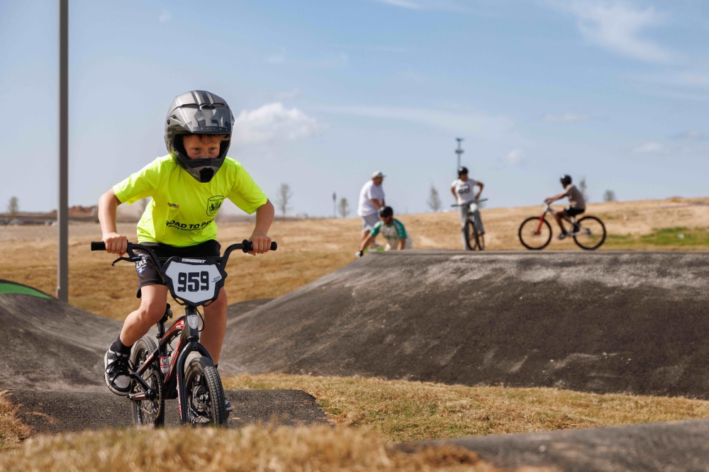 Kid rides a motor bike at Fairway Park with bike pump tracks and disc golf at Mayfair in New Braunfels