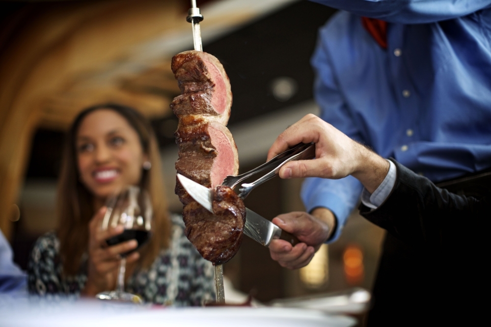 Fogo de Chão guests can watch chefs butcher and grill meats at the open-air churrasco grill in the center of the dining room. (Courtesy Fogo de Chão)