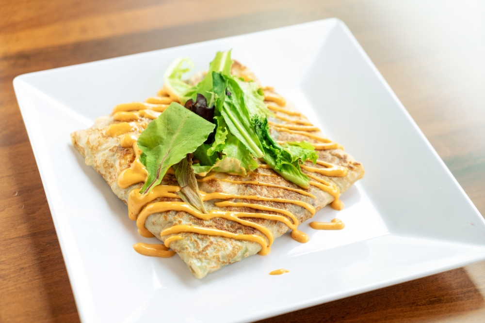 The fast-casual cafe is known for its made-to-order sweet and savory crepes and waffles. A savory crepe option is Mediterranean crepe (pictured). (Courtesy Coco Crepes & Coffee)