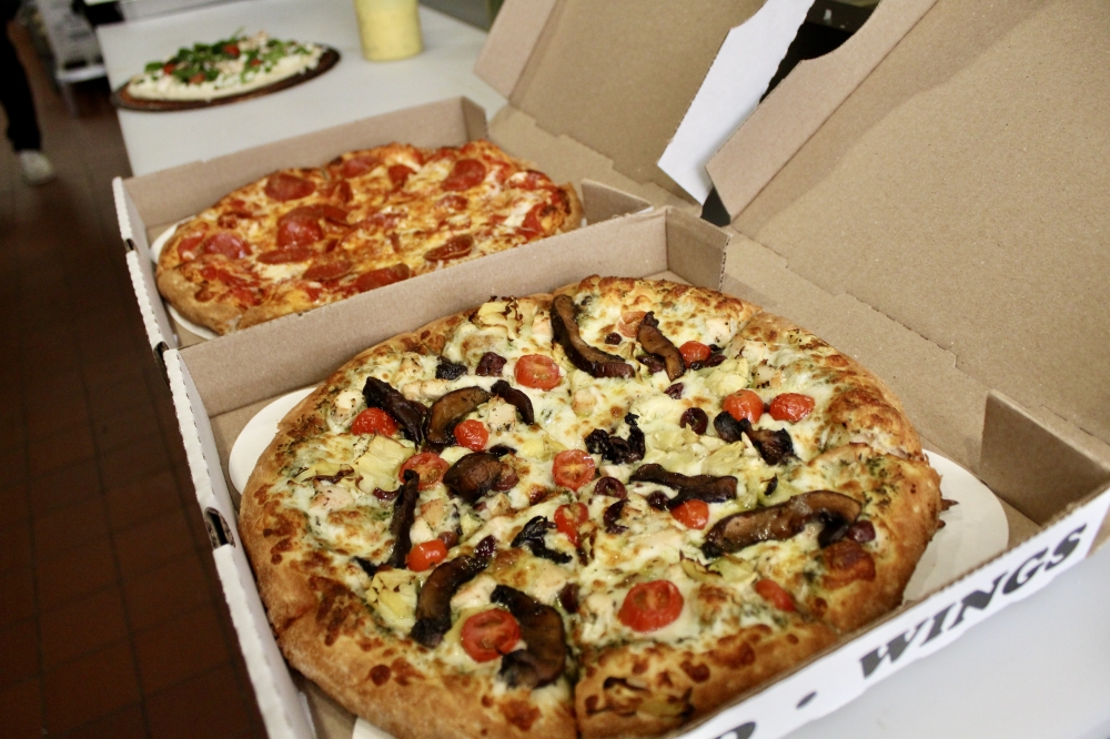Pizzaiolo's signature pizza ($23.99) is made with pesto, chicken, kalamata olives, artichoke hearts, portobello mushrooms and cherry tomatoes. (Jovanna Aguilar/Community Impact)