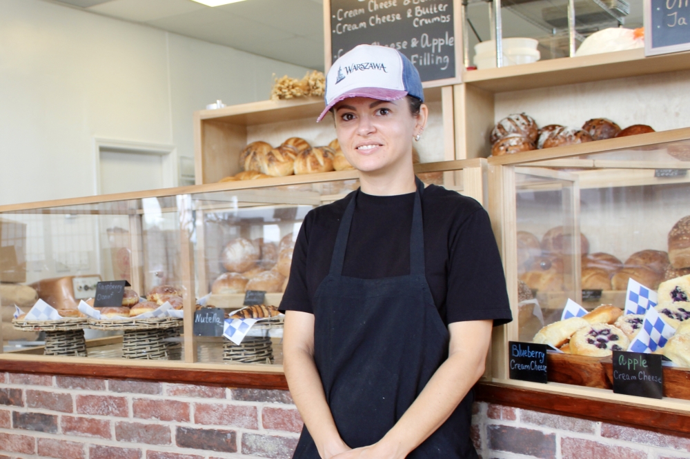 Owner Oksana Ramotowski stands in front of her bakery counter where she offers European baked goods. (Jovanna Aguilar/Community Impact)