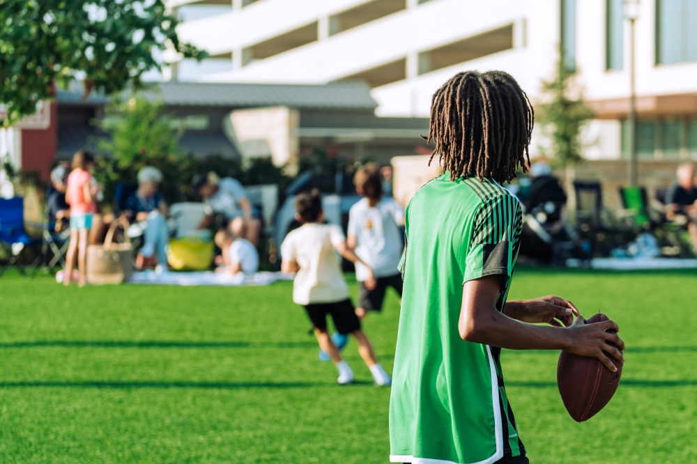 Child playing football after seeing the Hutto event calendar