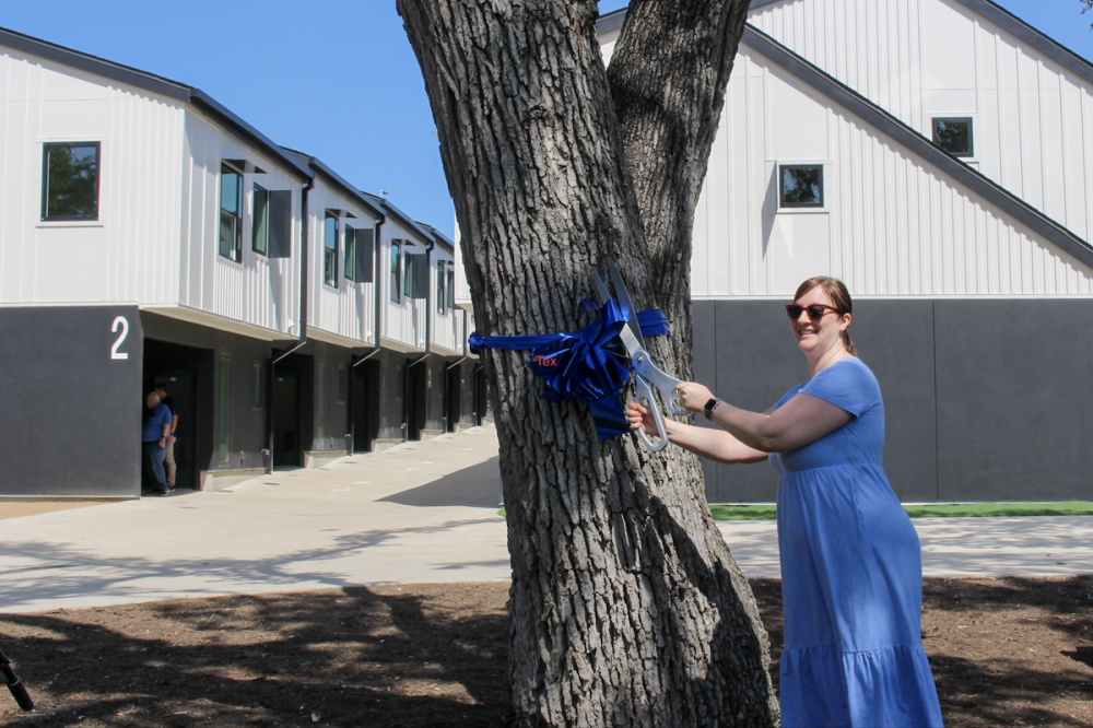 Brianna Berry, one of the Industry SOMA's first buyers, cut part of the ceremonial ribbon to celebrate the opening of the townhome community. (Elisabeth Jimenez/Community Impact)