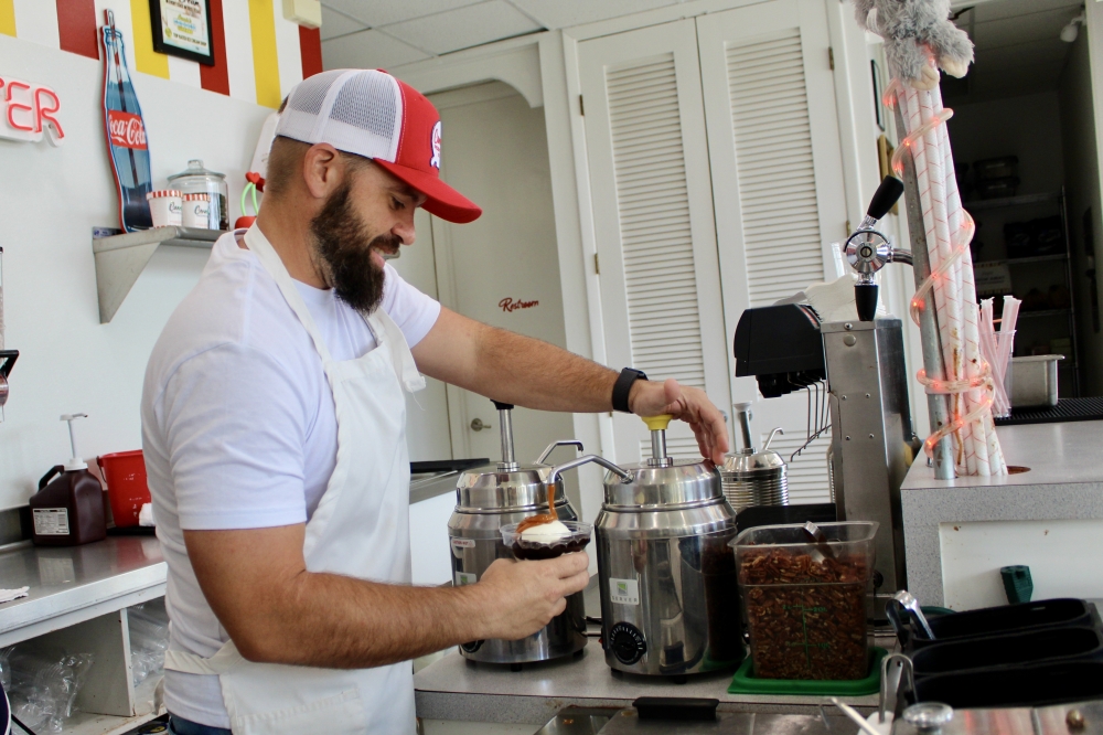 Co-owner Matthew Greatens prepares a Texas Turtle sundae. (Jovanna Aguilar/Community Impact)