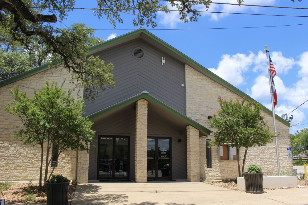 The Dripping Springs City Hall building underwent interior renovations beginning late 2024, adding new office space, upgraded technology, a renovated council chamber and more. (Bill Foulds gave a speech at a ribbon cutting marking the opening of the new Dripping Springs city hall building located on Mercer Street. (Dripping Springs Mayor Bill Foulds (center, right), City Council Member Geoffrey Tahuahua (right), City of Dripping Springs staff and other community members celebrated the opening of the newly renovated city hall building during a ribbon cutting June 26. (Elisabeth Jimenez/Community Impact)