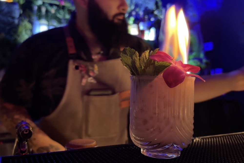The Pistachio Mai Tai ingredients include Planteray 3 Star, El Dorado 8, Hamilton 151 rums, pistachio orgeat, orange liqueurs, fresh lime, a flower and fire. (Roo Moody/Community Impact)