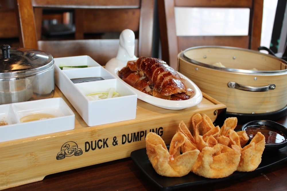 A traditional serving of Peking duck ($31.95) offered at Duck & Dumpling, along with an appetizer of cheese crab puffs ($7.95). (Andrew Creelman/Community Impact)