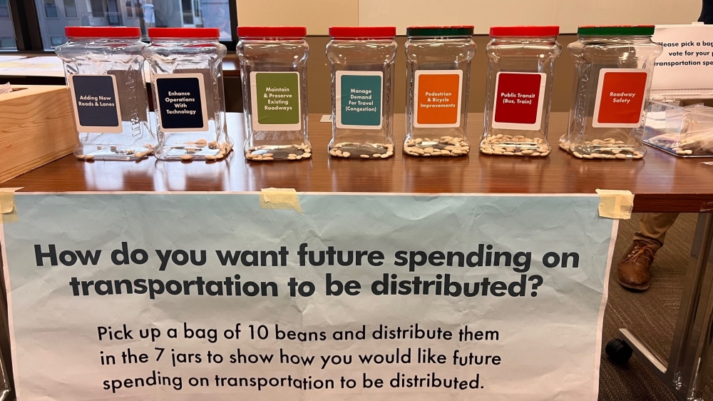 During one section of the public meeting, attendees were given a small plastic bag of beans to drop in buckets labeled with various transportation topics to signify where they would like to see future transportation investments. (Melissa Enaje/Community Impact)