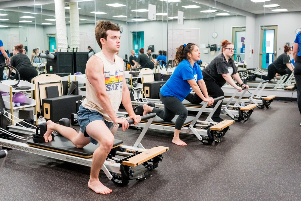 Pilates class stretches on reformer machine