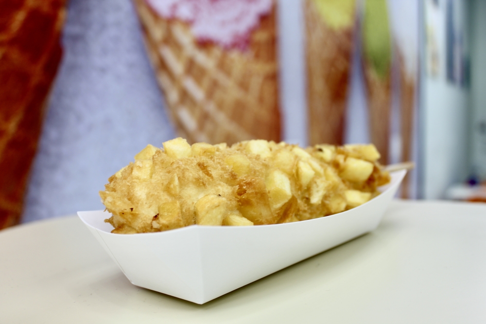 The potato corn dog ($6.95) combines Korean street food and American comfort. Each corndog is made fresh to order and can be customized with your choice of filling. (Jovanna Aguilar/Community Impact)