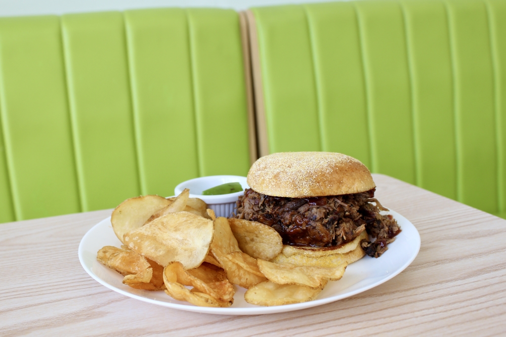 The Famous Pulled Pork Sandwich ($16) is smoked in applewood in a meat smoker in the back of the restaurant. (Jovanna Aguilar/Community Impact)