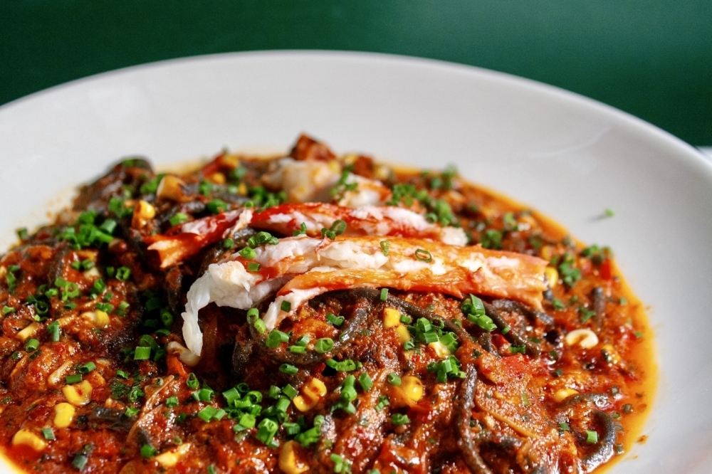 An example of a Milton's pasta dish includes squid ink chitarra tossed in a charred tomato sauce with king grab and roasted corn. (Courtesy Milton's via Facebook)