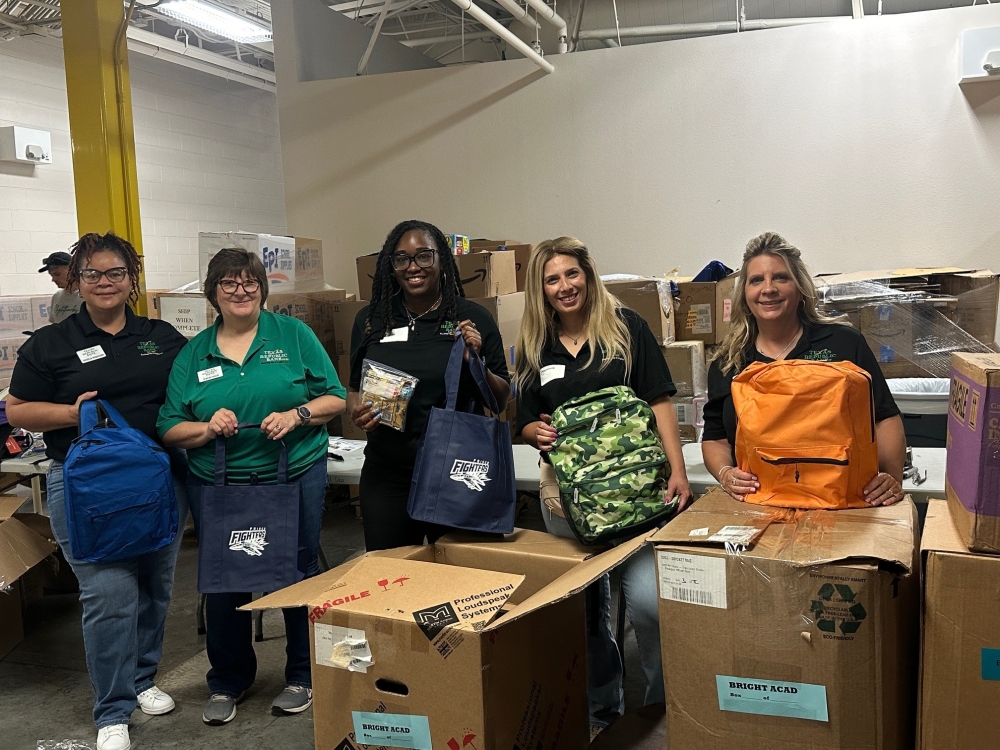 Bank employees stuff backpacks for a nonprofit