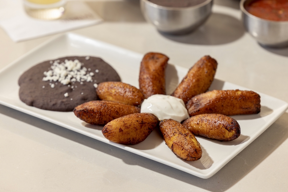 The platano frito ($12) includes ripe plantain, fried and is served with black beans and sour cream. (Courtesy Gloria’s Latin Cuisine)