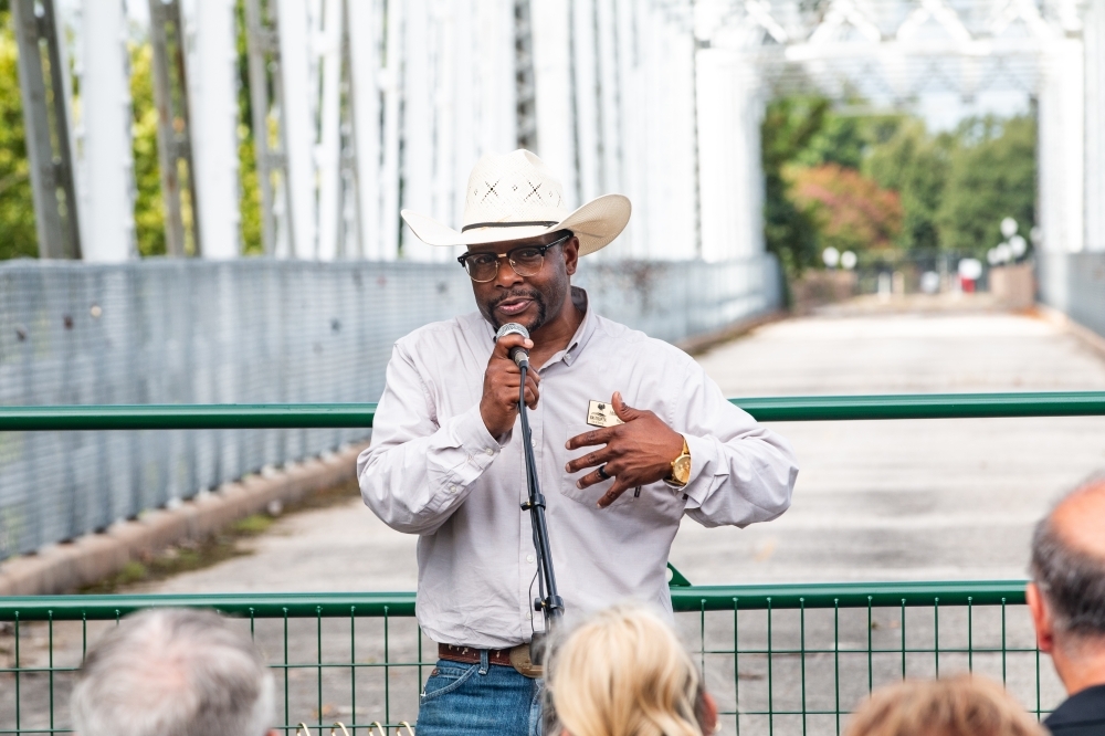 Bastrop Mayor Ishmael Harris welcomes residents to a rehabilitation kickoff event July 26 for the Old Iron Bridge project. (Joel Valley/Community Impact)