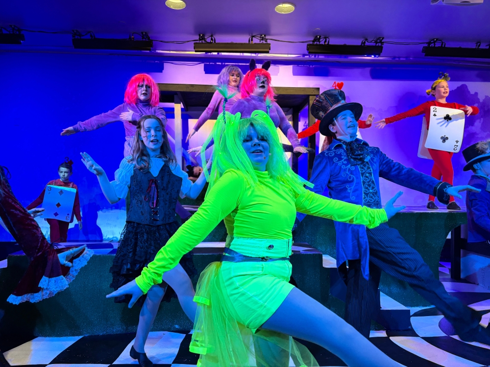 Kids on stage in neon costumes