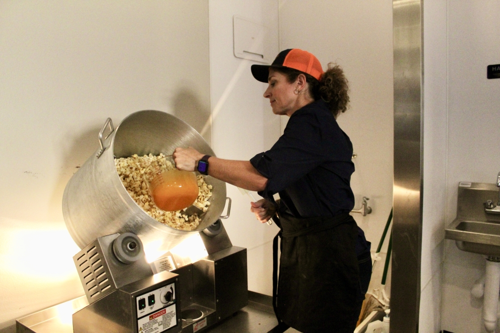 Julie Long prepares a batch of cheddar popcorn. (Jovanna Aguilar/Community Impact)