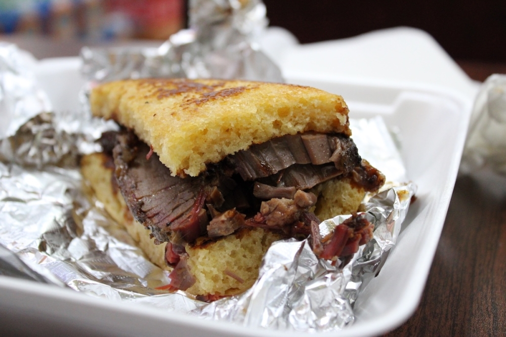 The beef brisket sandwich is packed with sliced meat and topped with a sweet Johnny bread. (Andrew Creelman/Community Impact)