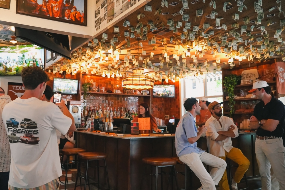 Inside Victory Lap Rainey Street bar, walls lined with Longhorn memorabilia celebrate The University of Texas at Austin athletic history. (Courtesy Victory Lap)