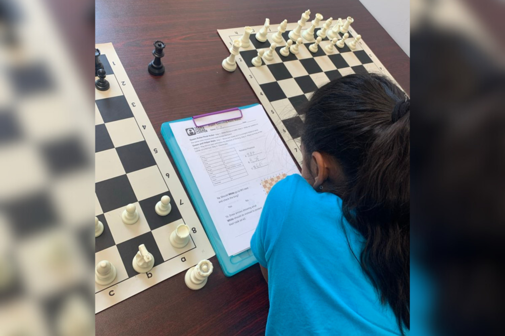 Student looking at chess board